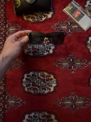 Svarta Ray-Ban Wayfarer solglasögon - Klassiska svarta Ray-Ban Wayfarer solglasögon, modell RB2140. Snygg tidlös design med breda bågar och mörka glas. Perfekta för att höja din stil och skydda ögonen mot solen. Kommer med originalfodral.