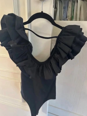 Svart volang body Zara - Snygg svart volang body från Zara. Trendig och i bra skick. Lånade bilder. storlek L men passar också M