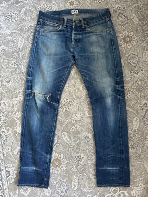 Blå selvedge jeans från Edwin - Säljer ett par superschyssta japanska Edwin selvedge jeans. De har snygga slitningar och är i bra skick. Storlek 32/32. Bara att hojta till om det är något du undrar över! 