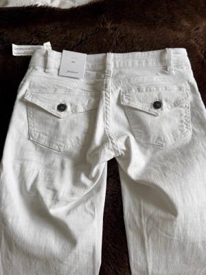 Vita raka jeans med fickdetaljer -  Vita bootcut jeans ifrån SubDude, aldrig använda med prislappen kvar. Kan tyvärr inte ta nån bild på eftersom att jeansen är för små för mig. Sitter som en XXS nypris 700kr