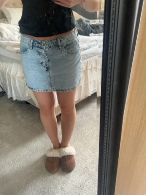 Ljusblå jeanskjol med fem fickor - Säljer en klassisk ljusblå jeanskjol i kort modell med fem fickor och knappgylf. Kjolen har en rak passform. Aldrig använd🥰
