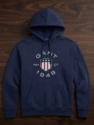 Mörkblå hoodie från Gant - Snygg mörkblå hoodie från Gant med stort tryck framtill som visar Gant-loggan och texten '1949'. Hoodien har huva med dragsko och en stor magficka. Perfekt för en avslappnad och sportig stil.