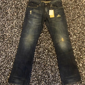 Midas Jeans Bootcut - Nya Midas jeans från Japan med asnajs wash samt snygga hål, har en bootcut/flared passform. Midja platt 38 cm, ytterben 102 cm, innerben 80 cm, benöppning 23,5 cm. Hör av er om ni har några frågor samt bud!