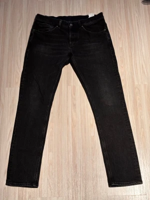 Svarta Dondup Jeans - Tja! Säljer dessa stilrena dondup jeans, passar 187cm 78kg — Storlek:33 — Svarta — Skick 9/10 — Nypris: 3000kr (Cm) Längd: 103 Midja: 42 Lårbredd 10 cm från skrevet: 22 Innersöm: 77 Det är bara att höra av sig, priset är inte hugger i sten!