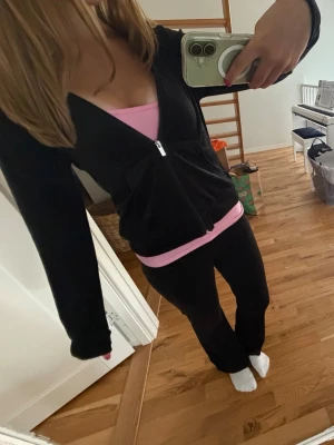 Svart velour loungewear set - Mysigt svart loungewear set i mjuk velour med zip-hoodie och matchande byxor från gina tricot. Hoodien har dragkedja, fickor och huva. Perfekt för chill dagar hemma eller när du vill vara bekväm men ändå se snygg ut.