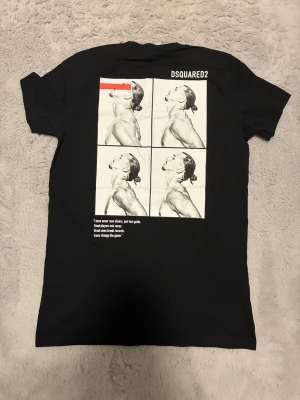 Svart DSQUARED2 ICON t-shirt - Svart t-shirt från DSQUARED2 med stort vitt tryck 'ICON IBRAHIMOVIC' på framsidan och grafiskt motiv i svartvitt på ryggen. Klassisk passform och rund hals. Perfekt statement-plagg för dig som gillar streetwear. Står M men passar S!
