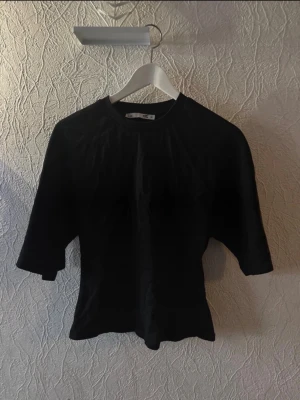 Svart topp med halvlånga ärmar - En stilren svart topp med rund halsringning och halvlånga ärmar. Modellen är figurnära och passar perfekt till jeans eller kjol. Enkel och snygg design som funkar till många olika looks. ✨🤍🫶🏻