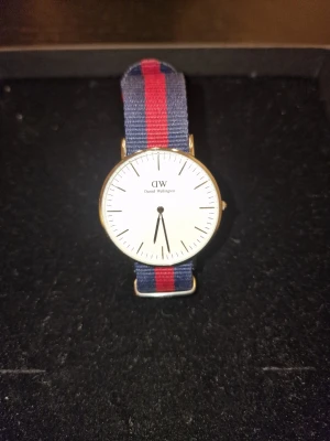 Klassisk Daniel Wellington klocka - Stilren klocka från Daniel Wellington med vitt ur och guldfärgad boett. Perfekt accessoar för dig som gillar klassisk och enkel design.