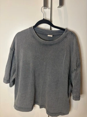 Grå t-shirt från Bershka - En enkel och stilren grå t-shirt från Bershka i loose fit. Perfekt för en avslappnad och trendig look. Använd endast en gång