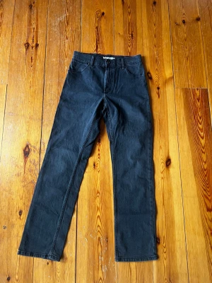 Svarta raka jeans från Wrangler 30/32 - Säljer ett par svarta jeans från Wrangler med rak passform och klassisk femficksdesign. Jeansen har normal midja och är tillverkade i ett slitstarkt denimtyg. Perfekta för en avslappnad och stilren look.