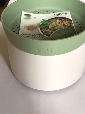 River Cooker - Praktisk Rice Cooker från Lékué i plast med rund form. Locket är ljusgrönt och har små hål för enkel avrinning av vatten. Perfekt för att laga pasta snabbt i mikron. Enkel att använda och rengöra.