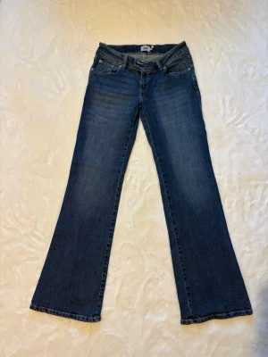 Blå bootcut jeans med broderade fickor - Säljer ett par blå bootcut jeans med snygga detaljer på bakfickorna. Skulle säga att de är ganska lågmidjade. Köpta på lager157 och de är använda 1/2 ggr🥰