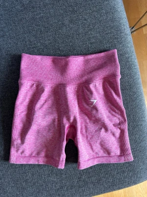 Gymshark träningsshorts - Rosa tränibgsshorts från gymshark som endast är använda en gång, hög midja och scrunch i baken. Stretchiga och sitter på plats, skriv vid frågor!💕
