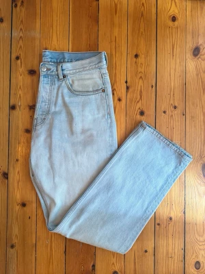 Ljusblå raka jeans från Weekday  - Säljer ett par snygga ljusblå jeans med rak passform ifrån Weekday. Klassisk femficksmodell med bälteshällor och dragkedja med knapp. Jeansen är i ett mjukt denimtyg som ger en avslappnad och trendig look.