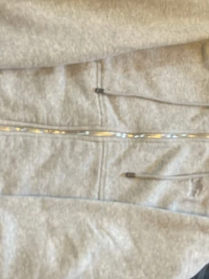 Grå zip hoodie med huva - Snygg grå zip hoodie från Burberry med klassiskt rutigt foder i huvan och dragsko. Tillverkad i mjukt sweatshirtmaterial och har en diskret broderad logga på bröstet. Perfekt för en avslappnad och trendig look. Aldrig använd pris är 350kr kan diskuteras vid snabb affär