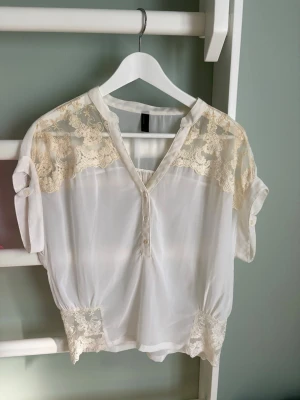 2-pack blusar - 2-pack blusar med spetsdetaljer från vero moda. Den cremefärgade har börjat få lite missfärgningar på spetsen ( se sista bild ) då den har ett par år på sig men annars är båda i mycket bra skick. Stl: XS