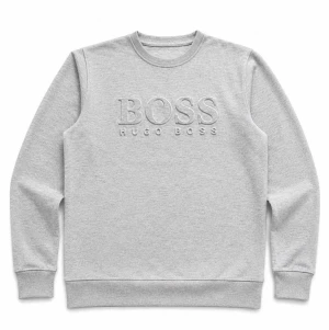 Grå sweatshirt från Hugo Boss - Snygg ljusgrå sweatshirt från Hugo Boss med broderad logga framtill. Tröjan har rund halsringning, ribbade muddar vid ärmslut och nederkant samt en clean och stilren look. Perfekt för dig som gillar klassisk streetwear.