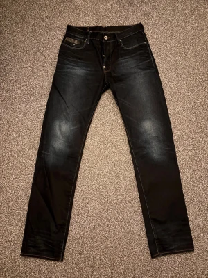 Mörk blåa G-Star jeans  - Tjenare säljer ett par tvär fetta G-Star jeans i färgen mörkblå. De har en unik design på backen o har en fett wash på benen o snygga detaljer. De har dock slitningar på hälen som du ser på bilden. Längden är 114 cm
