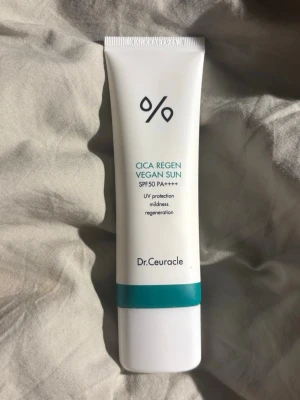 Cica Regen Vegan Sun SPF 50 - Cica Regen Vegan Sun SPF 50 PA++++ från Dr.Ceuracle är en solkräm i vit tub med turkos detalj. Ger högt solskydd, är vegansk och passar för känslig hud. Tuben är smidig att ta med och har minimalistisk design. Köpte för runt 250kr och är endast öppnad och testad en gång 🩵