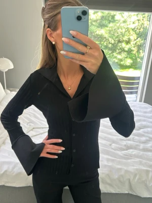 Svart topp med vida ärmar - Svart topp från Avora med snygg krage och vida ärmar. En fin men basic topp som funkar till allt. 