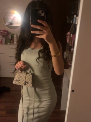 Ljusgrön ribbad långklänning - Snygg ljusgrön långklänning med ribbad struktur och ärmlös design. Klänningen har en kroppsnära passform och rund halsringning, perfekt för dig som gillar stilrena och trendiga plagg.