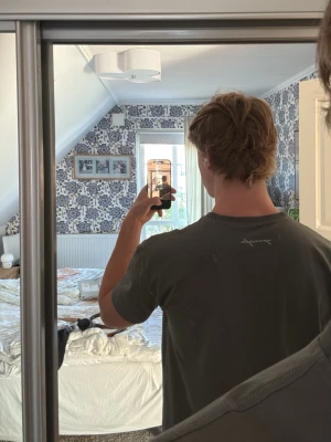 Mörkgrå young LA t-shirt - Säljer en mörkgrå t-shirt med enkel design och diskret tryck på bröstet och nacken. T-shirten har rund hals och korta ärmar, perfekt för en avslappnad stil. Tillverkad i mjukt bomullsmaterial för skön komfort.
