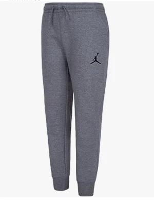 Nike Air Jordan mjukisbyxa Jr Stl 170. *Ny* - Snygga grå mjukisbyxor med resår i midjan och dragsko samt ribbade muddar vid bensluten. Byxorna har en svart Jordan-logga på låret och är tillverkade i mjuk bomull. Perfekta för chill eller träning.
