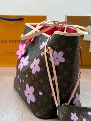 Väska Neverfull - Helt ny Neverfull väska med murakami blommor. Väskan är i äkta läder och har röd insida