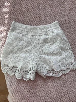 Vita spets shorts  - Säljer ett par vita shorts från Pense à toi med vacker spets och broderade detaljer.
