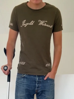Olivgrön T-shirt - In Gold We Trust Olivgrön T-shirt sitter i strl S! Bra skick utan nåra defekter och hör gärna av er vid frågor elr funderingar!!