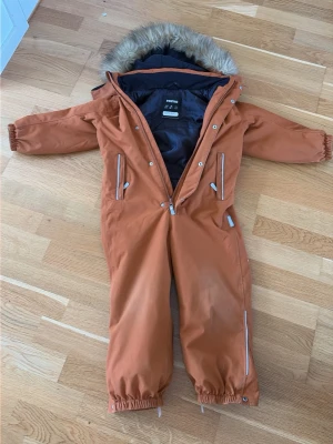 Rustbrun overall från Reima - Jag säljer denna rostbruna overallen från reima som fungerar perfekt i allt lek och bus i alla väder. Luvan går att ta av och på och det ända som behövs nytt är nya stroppar under fötterna💕 skriv vid minsta fundering!