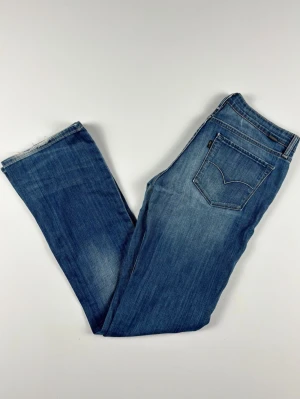 Rare Black Tab Levi's bootcut jeans blå W29 L32 - RARE Levi's Black Tab jeans med riktigt snygga detaljer. Från Always Honestly Made kollektionen. Väldigt unika jeans! Unisex Färg: Blå Passform: Bootcut Storlek: W29 L32 Skick: B Grade Mått [platt] (±1 cm): A: 39 cm B: 103 cm C: 26 cm D: 21 cm Tveka inte att höra av dig vid frågor eller funderingar.  Skickas snabbt!