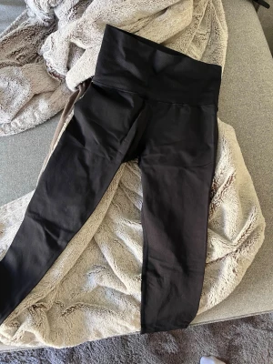 Svarta leggings  - Säljer ett par svarta leggings med tight passform. De är stretchiga och mjuka, perfekta för en avslappnad look eller till träning. Materialet känns som bomullsmix med lite elastan för extra komfort. Oanvända 