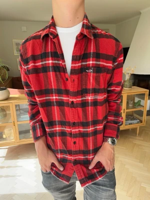 Hollister flanel skjorta herr röd rutig vintage - Klassisk röd- och svartrutig flanellskjorta från Hollister California. Perfekt för en avslappnad och snygg stil!Märke: HollisterStorlek: M.        Färg: Röd/Svart/VitSkick: Jättefint skick, inga defekter.Hör av dig om du har några frågor! Fraktar snabbt
