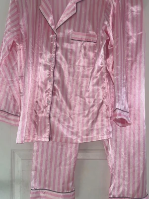 H Nathalie rosarandig pyjamas Victoria’s Secret kopia - Rosarandrig pyjamas från H Nathalie. Ser ut som en dupe från Victoria’s Secret! Aldrig använd! 🚨Tar bara emot betalningar via Swish!!! Om du vill ha fler bilder eller har frågor är det bara att skriva till mig!!!🚨