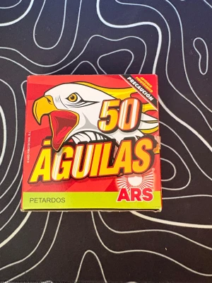 Petarder 50-pack Águilas ARS - Säljer en oöppnad ask med 50 stycken små petarder av märket Águilas från ARS. Förpackningen är röd och gul med en örn på framsidan. Petarderna är inslagna i rött papper med gröna stubiner. Perfekt för dig som gillar fyrverkerier. Skriv om du har några frågor eller vill ha mer bilder!👍🏼🫶🏼