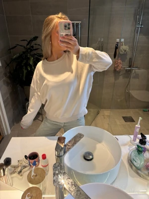 Vit oversized hoodie - Säljer en vit oversized sweatshirt med rund hals och långa ärmar. Hoodien har en enkel och clean design utan tryck eller logga, perfekt för en chill och avslappnad stil. Tillverkad i mjukt material som känns skönt mot huden.