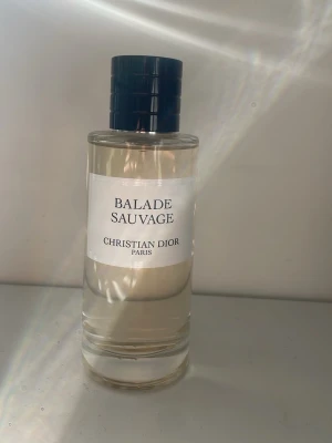 Balade Sauvage parfym från Dior 125ml - Balade Sauvage från Christian Dior är en exklusiv parfym i en stilren, genomskinlig glasflaska med svart cylinderformad kork. Doften har en elegant och minimalistisk design med tydlig etikett framtill. Perfekt för dig som gillar lyxiga och klassiska parfymer.Ej ANVÄND