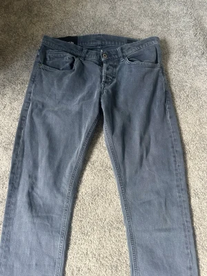 Grå dondup  jeans med 4 fickor - Snygga grå jeans med rak passform och Jeansen har bälteshällor, knappgylf och diskreta sömmar. Materialet ser ut att vara mjuk bomullsdenim som ger en avslappnad look. Perfekta för dig som gillar stilrena och enkla jeans.