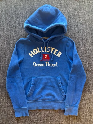 Hollister hoodie ~ 2000’s yk2 - Sjukt eftertraktad Hollister hoodie ~ sällsynt vintage modell som inte längre produceras | st S | färg blå | klassisk passform | sällsynt 2000’s modell | OBS kan gå ner lite i pris vid snabb affär! 🏄