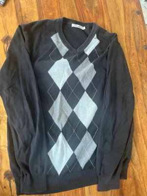Svart argyle stickad tröja Dressmann - Klassisk svart stickad tröja från Dressmann. Har blivit för liten av mig. Väldigt snygg tröja med argyle mönster. Är använd men mycket bra skick.