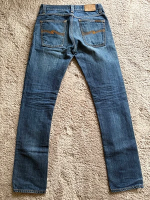 Nudie Jeans Grim Tim  - Modell: Grim Tim🪬  Färg: Blå/Mörkblå🪬  Storlek: W31 L32 🪬  Mått: W40cm L107cm Benöppning 17cm🪬  Skriv vid minsta fundering!🪬