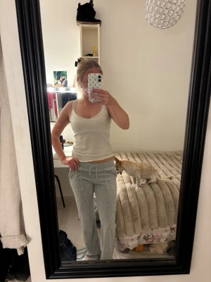 Grå mjuka loungewear-byxor - Säljer ett par grå mjuka loungewear-byxor med dragsko i midjan och raka ben. Byxorna har fickor på sidorna och är perfekta för att chilla hemma. Materialet ser ut att vara bomull eller bomullsblandning för extra komfort.