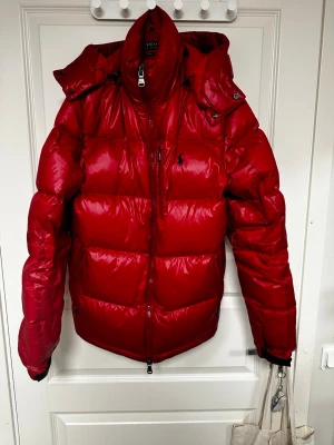 Röd pufferjacka från Polo Ralph Lauren - Snygg röd pufferjacka från Polo Ralph Lauren i storlek S. Passar perfekt för dig mellan 173-180. Säljer lite billigare då det inte är i säsong än. Priset går att diskutera för jag vill få bort den.