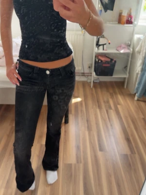 Svarta bootcut jeans med låg midja - Säljer ett par svarta bootcut jeans med låg midja och klassisk femficksdesign. Jeansen har en snygg passform som sitter tajt över låren och släpper ut vid bensluten. Perfekta för en trendig och avslappnad look. Jag är 174 och innebensmåttet är 86cm 