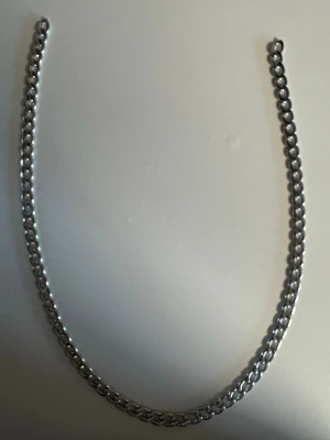Kraftigt silverfärgat kedjehalsband - Säljer ett chunky halsband i silverfärgad metall med breda, ovala länkar. Kedjan har en stilren och modern look som passar perfekt till streetwear eller för att ge outfiten edge. Länkarna är tätt sammanlänkade och halsbandet känns rejält.