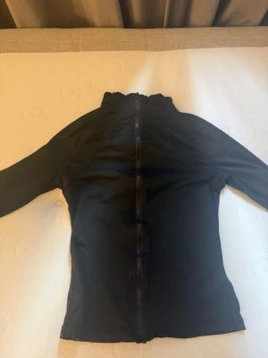 Svart vindjacka från SHEIN XS - Snygg svart vindjacka från SHEIN i storlek XS. Jackan har hel dragkedja framtill, hög krage och är tillverkad i ett lätt material som passar perfekt för blåsiga dagar. Enkel och stilren design utan synliga loggor eller detaljer.