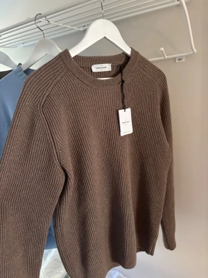 Gran sasso brun genser - Hei. Selger denne brune gran sasso genseren i en ullblend. Genseren er lite brukt og lukter fortsatt av butikken. Aldri vasket Perfekt nå til høsten når det blir litt kaldere Denne genseren hadde passet fint med klær fra  polo ralph lauren, moncler, Burberry    Ai: Brun ullgenser fra Gran Sasso i str 50, normal i størrelsen. Grovstrikket med rund hals og ribbestrikkede kanter.