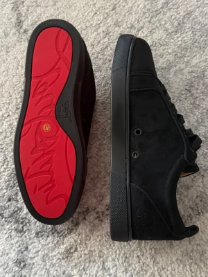 Christian louboutin skor - Stilrena svarta sneakers i mocka med klassisk röd sula och svarta skosnören. Med diskreta detaljer och bekväm innersula. Perfekta för dig som gillar en clean look. Jag säljer dessa helt oanvända christian louboutin skorna då de är för små för mig, hör gärna av dig om det skulle vara några frågor.
