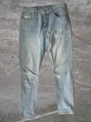 Levis 501 skinny - Säljer ett par ljusblå levis 501 skinny med klassisk femficksdesign. Jeansen har en något tvättad look och är tillverkade i denim. Perfekta för en avslappnad och trendig stil.